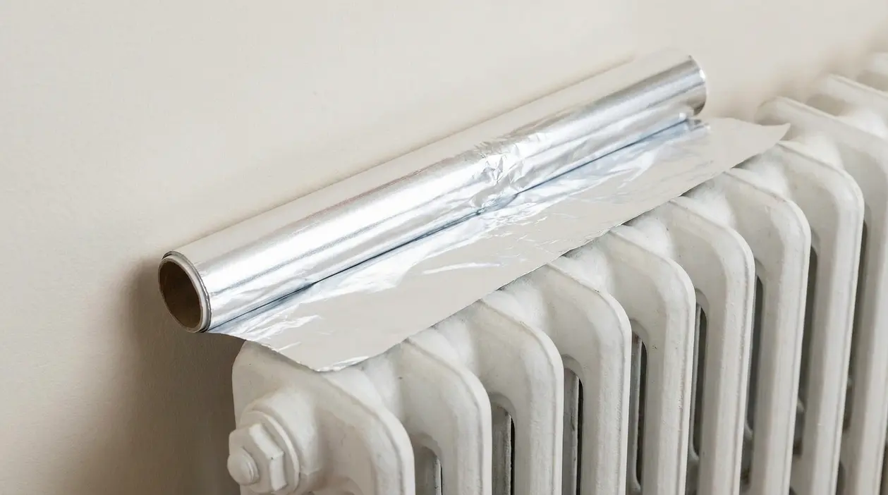 Rotolo di carta stagnola appoggiato su un termosifone bianco