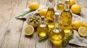 Bottiglie di olio d'oliva con limoni freschi, olive e rosmarino su un tavolo rustico